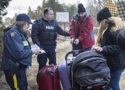 Police arresting asylum seekers for crossing the US-Canada border.
